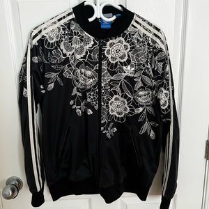 Black Adidas jacket with white flowered detailing